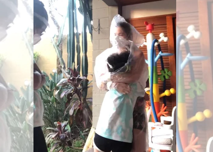 Samara Felippo usa capa de chuva para abraçar filhas que estão com covid-19